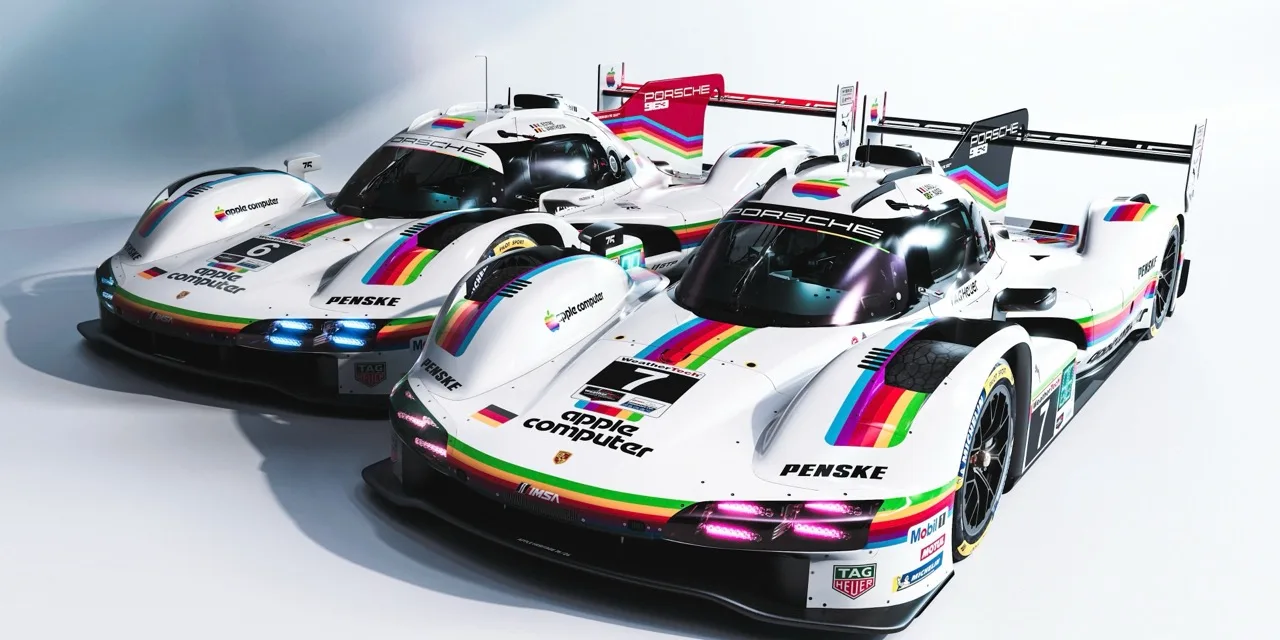 Two white Porsche 963 race cars in Penske livery, striped in the retro Apple rainbow and carrying the old 'apple computer' logo on the nose and doors